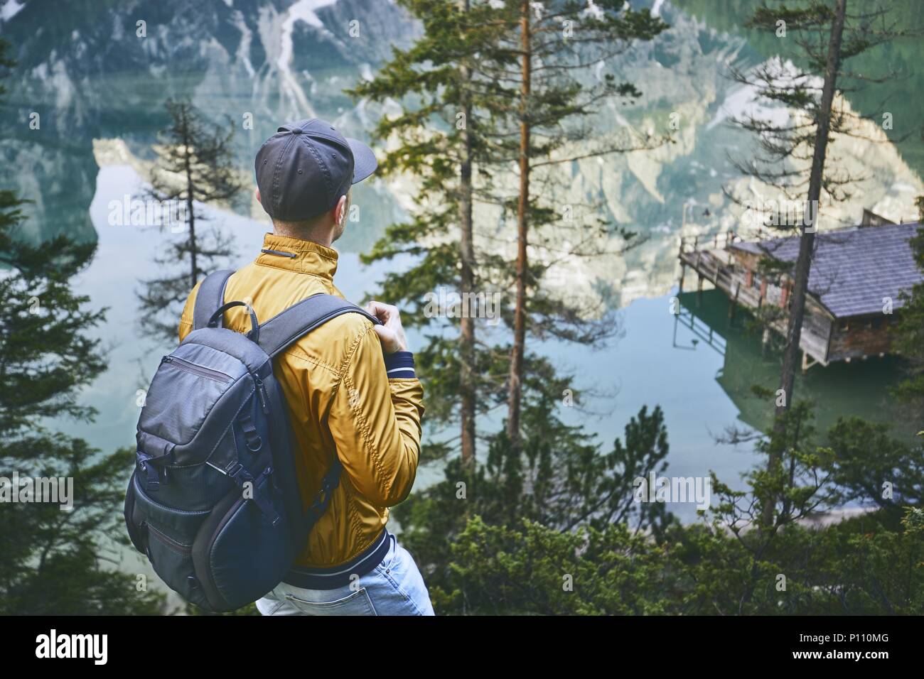 Jeune homme (touriste) avec sac à dos est de marcher à travers la forêt. Dans refelection Montagnes Lac Braies, Italie. Banque D'Images