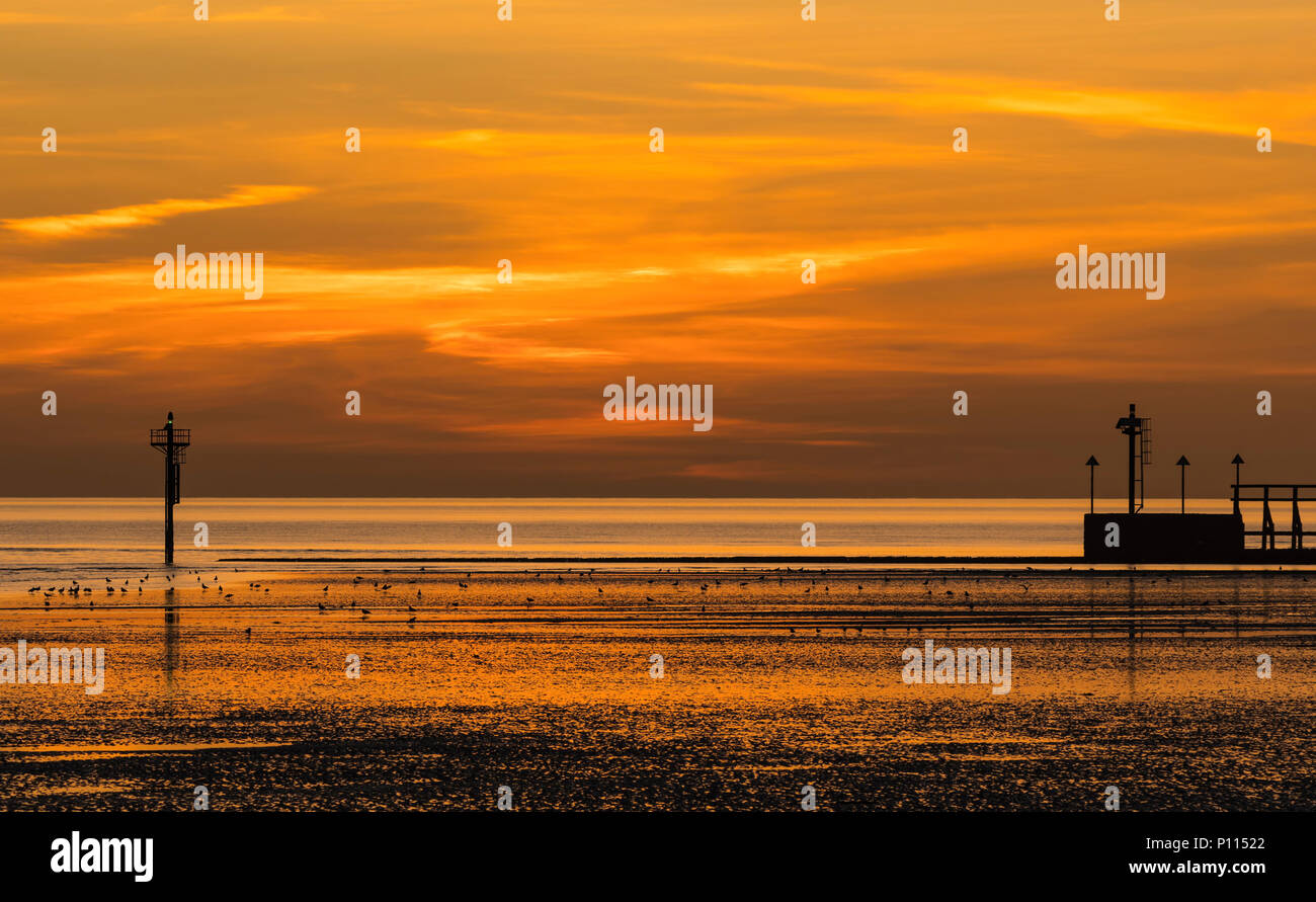 Beau ciel rouge et orange par la mer au crépuscule après le coucher du soleil, sur la côte sud dans le West Sussex, Angleterre, Royaume-Uni. Banque D'Images