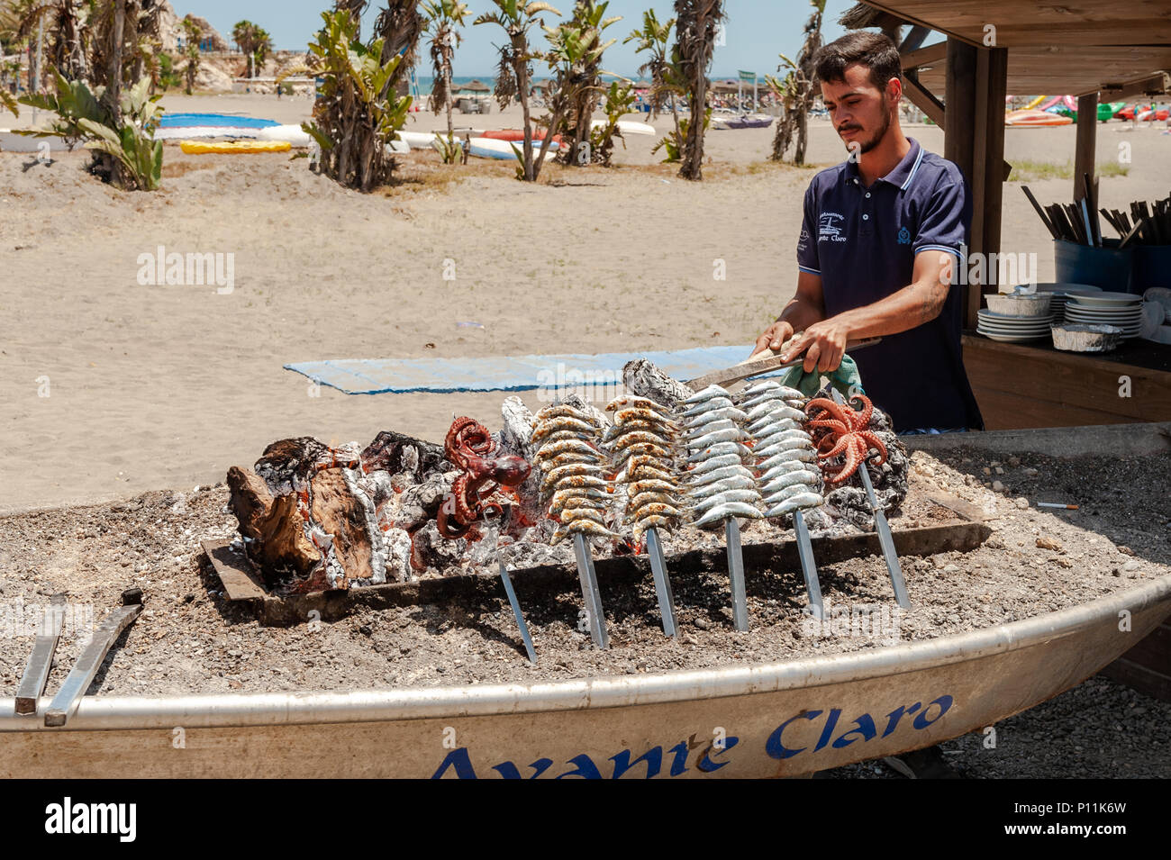 Man cooking sardines et le poulpe sur un barbecue sur la plage de Malaga, Axarquía, la Cala del Moral municipalité de Rincón de la Victoria, Malaga, Espagne Banque D'Images