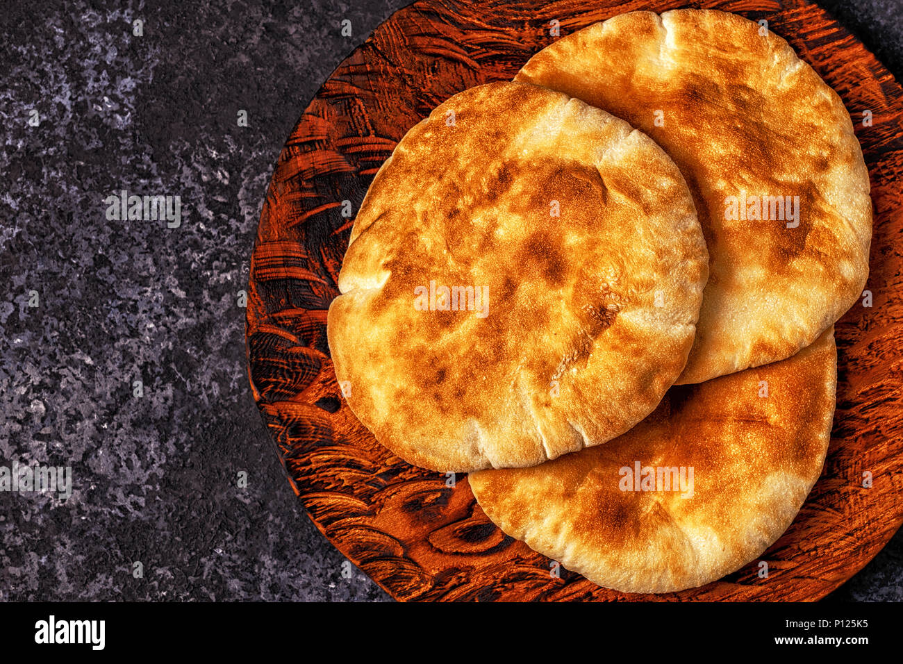 Le pain pita sur un tableau sombre, vue du dessus, copiez l'espace. Banque D'Images