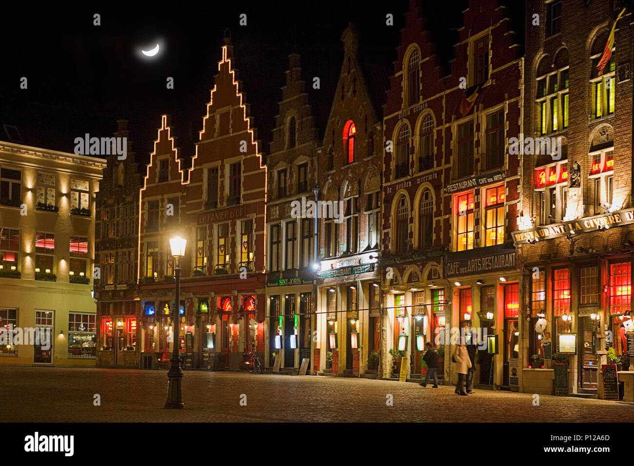 Le côté nord de la place du marché de nuit, éclairé brillamment avec cafés et bars, Brugge, Belgique Banque D'Images