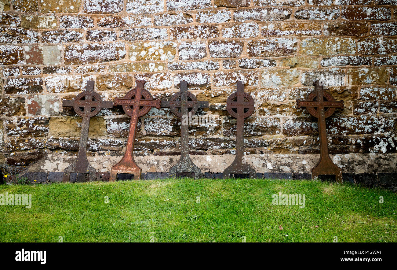 Old metal grave des marqueurs à l'église Saint Jean Baptiste dans le désert, la région de Shuckburgh, Warwickshire, England, UK Banque D'Images