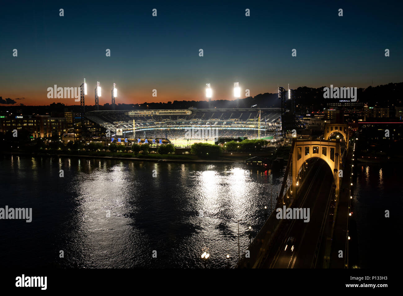 Pittsburgh, PA, USA - juin 6, 2-18 : Pittsburg Pirates PNC Park illuminé la nuit avec le trafic sur Roberto Clemente Bridge. Banque D'Images