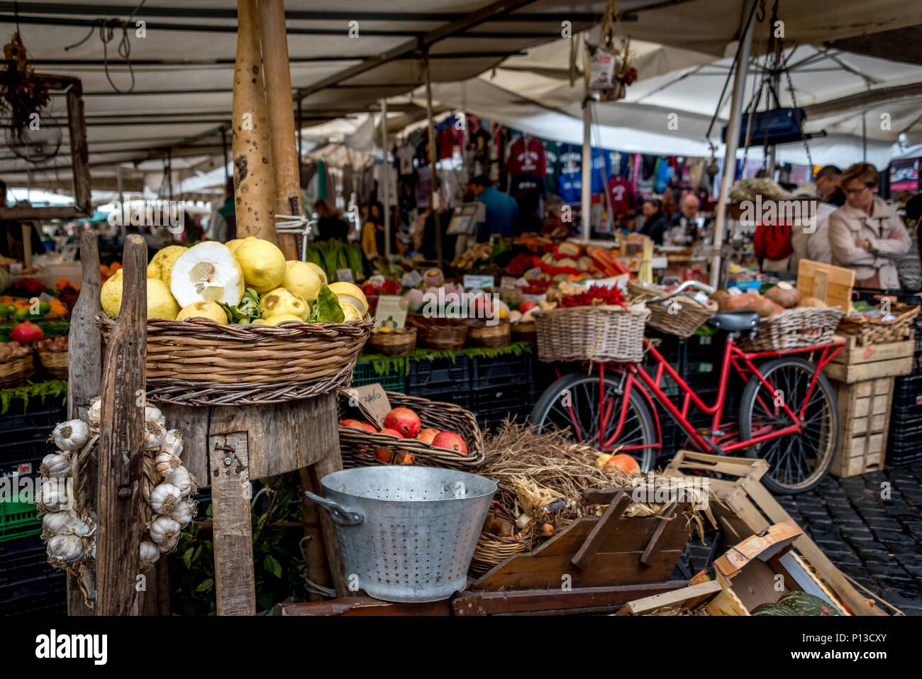 Campo de Fiori marché plein air, Rome, w/ location rouge avec des paniers et des tables avec panier de citrons, couronne de l'ail, d'autres produits sous les parasols Banque D'Images