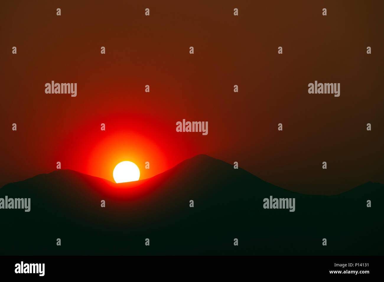 La fumée des feux de forêts crée une lueur orange au soleil sur les montagnes Rocheuses du Colorado ; USA ; Banque D'Images