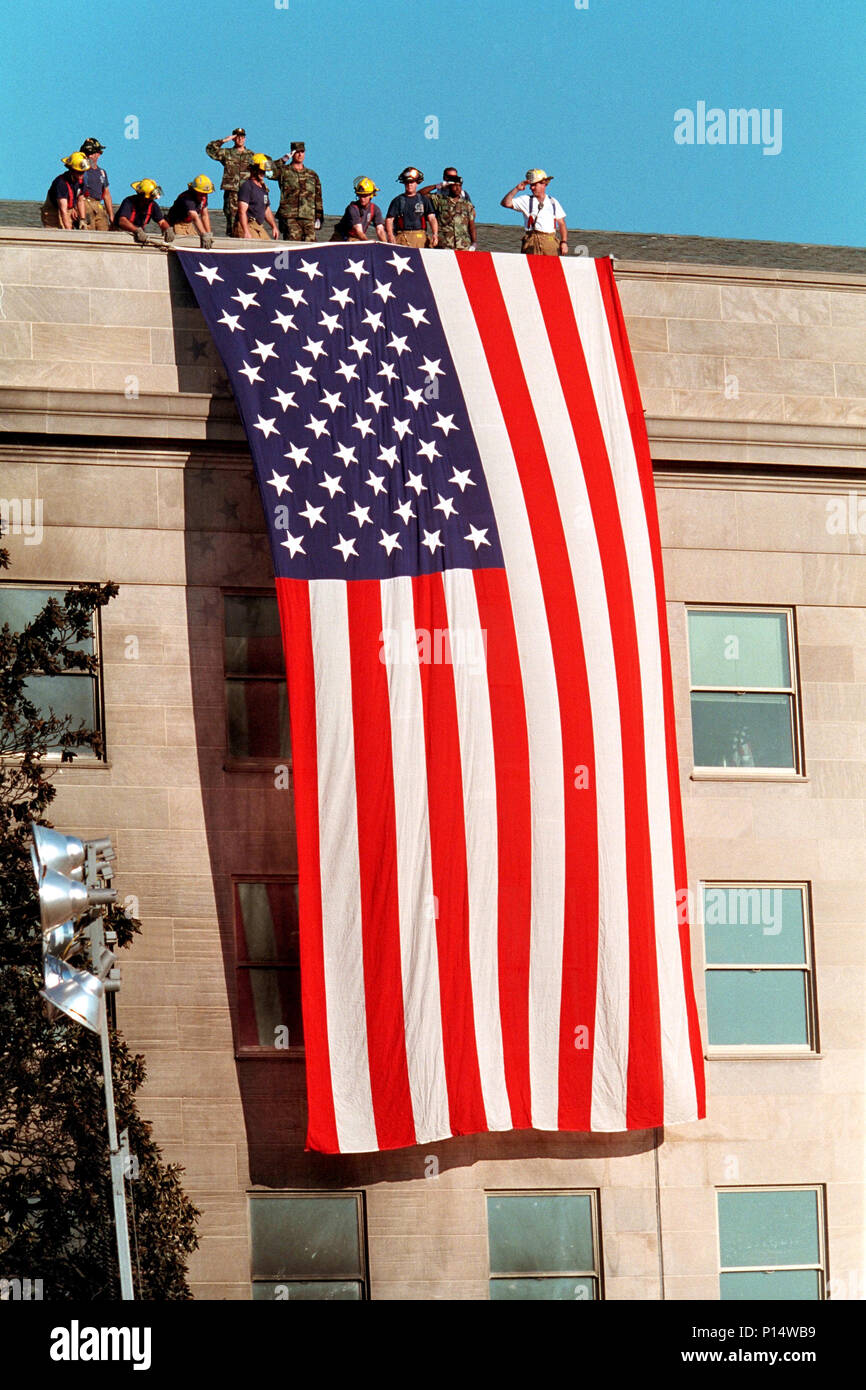 Les pompiers déploient un grand drapeau américain sur la pierre marqué du Pentagone Mercredi, 12 septembre 2001 à Arlington, Va., photo de Paul Morse Banque D'Images
