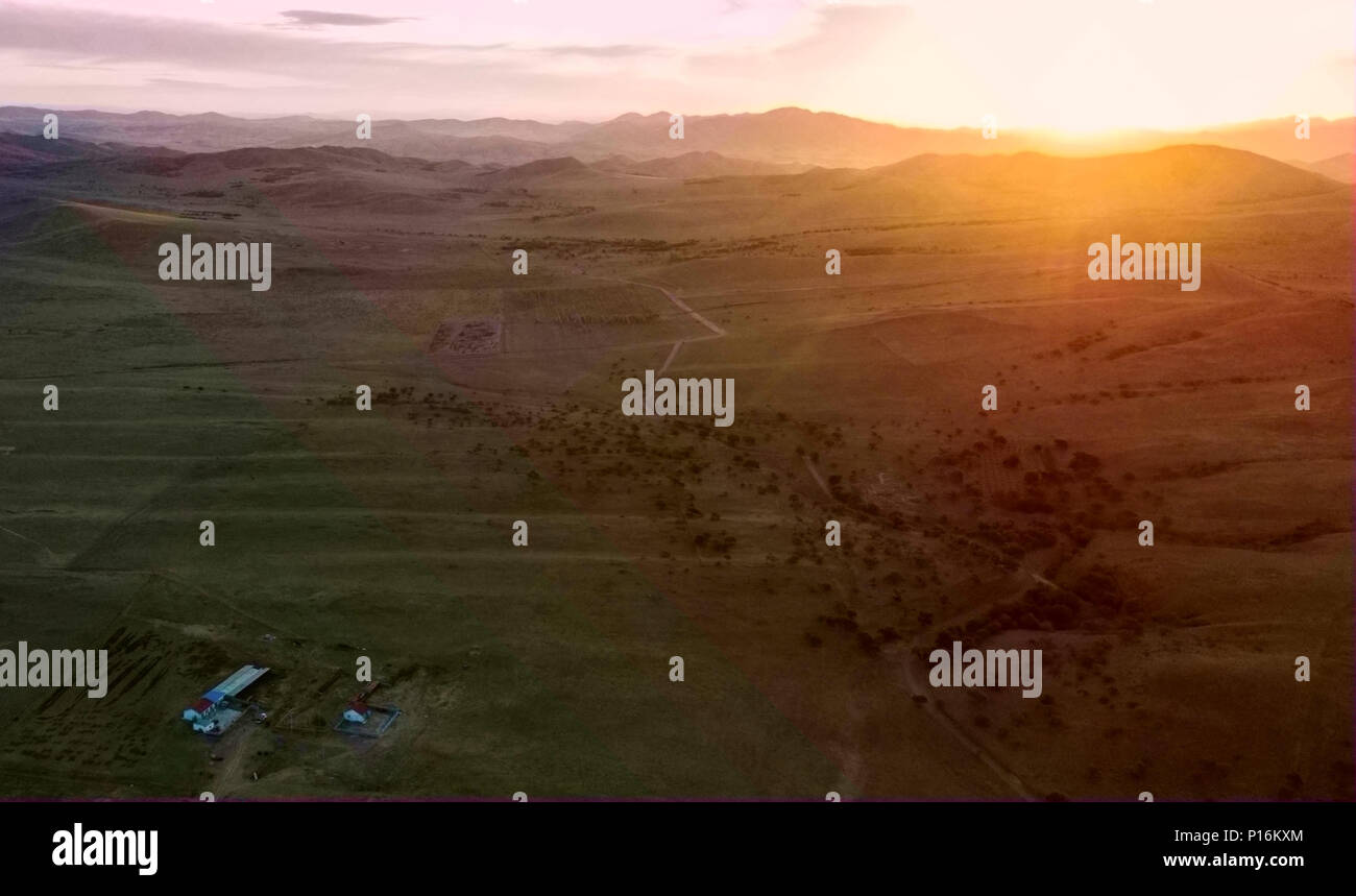 (180611) -- CHIFENG, 11 juin 2018 (Xinhua) -- photo aérienne prise le 5 juin 2018 montre le soleil se lever au-dessus de la prairie où Erden vit au Ar Horqin bannière dans la ville de Chifeng, Chine du nord, région autonome de Mongolie intérieure. Le 5 juin était le jour de la famille d'Erden pour déplacer leur bétail d'un pâturage d'été, à environ 40 kilomètres de leur famille. C'est une tradition pour les bergers nomades qui passent leurs vies à la suite de l'eau et de pâturages. Le transfert offre des bovins et moutons nourriture abondante et permet à la prairie de se renouveler. Erden et sa sœur dur leurs camions chargés de livin Banque D'Images