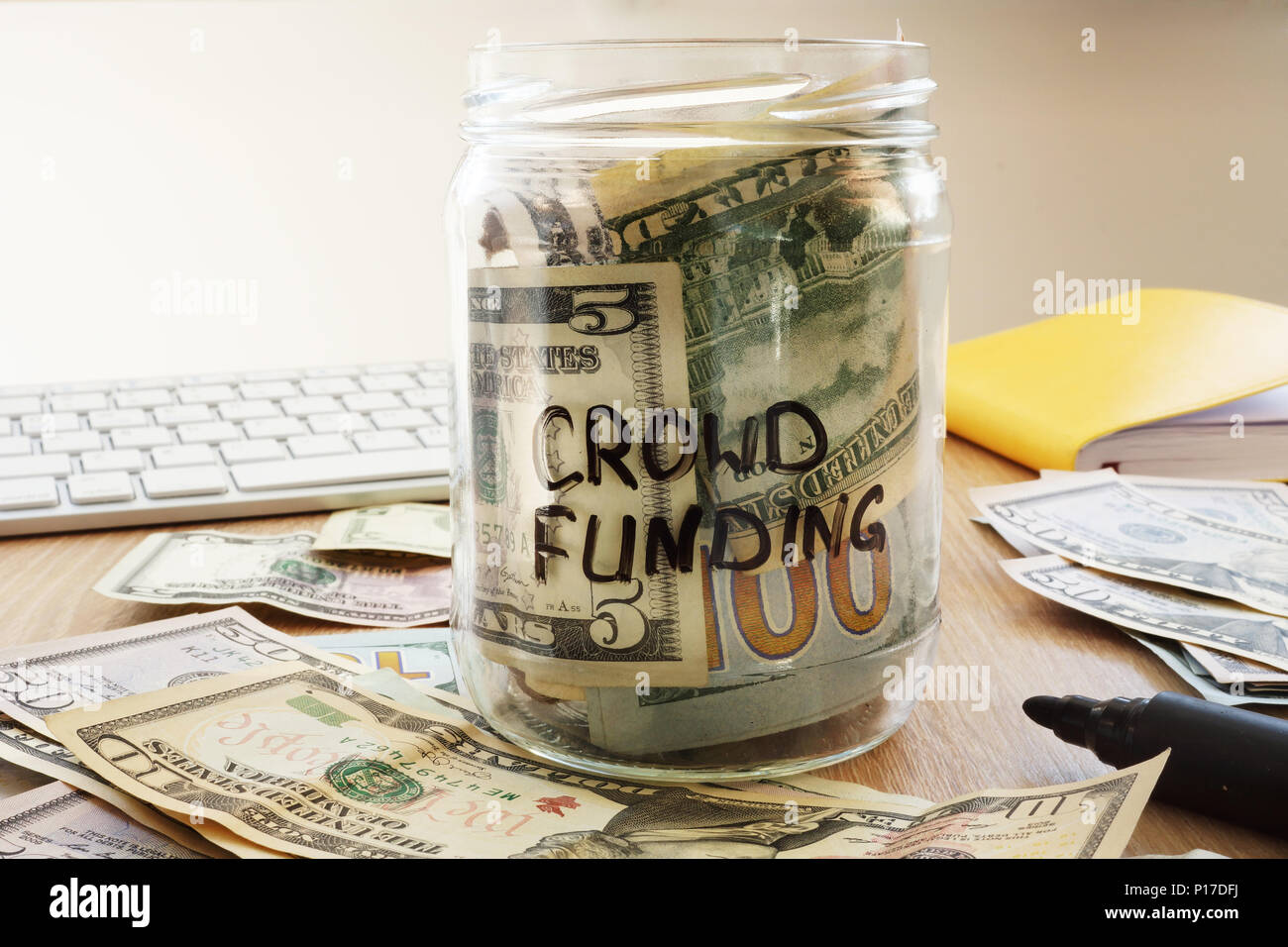 Crowdfunding écrit sur un pot avec des dollars. Banque D'Images