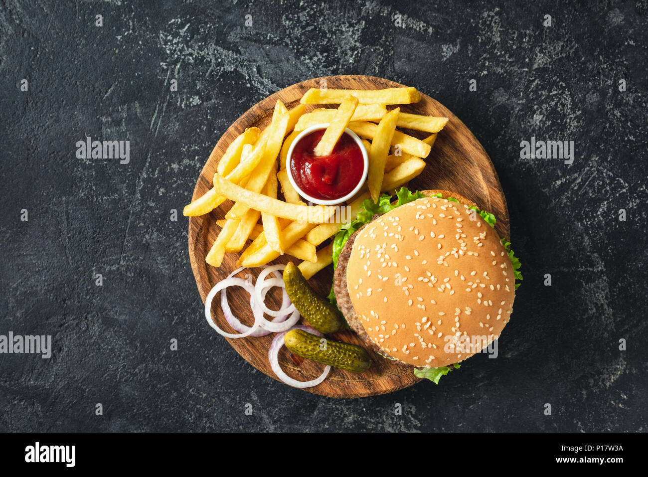 Burger, hamburger ou cheeseburger de frites, les cornichons et l'oignon sur planche