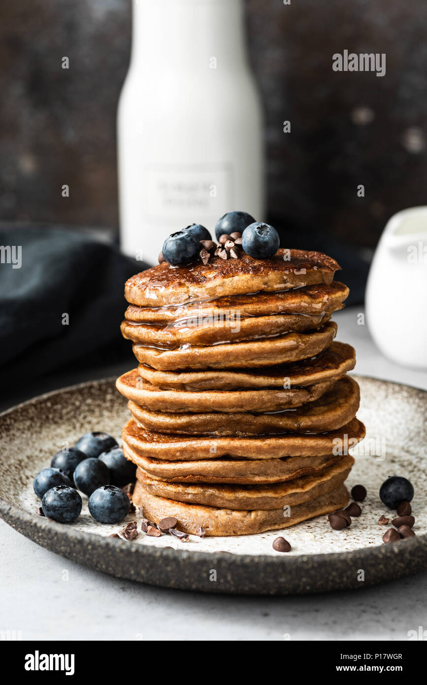 Crêpes aux bleuets avec l'avoine, le chocolat et le miel. Crêpes en bonne santé. Petit-déjeuner sain ou snack-concept. Vue rapprochée de la pile de crêpes Banque D'Images