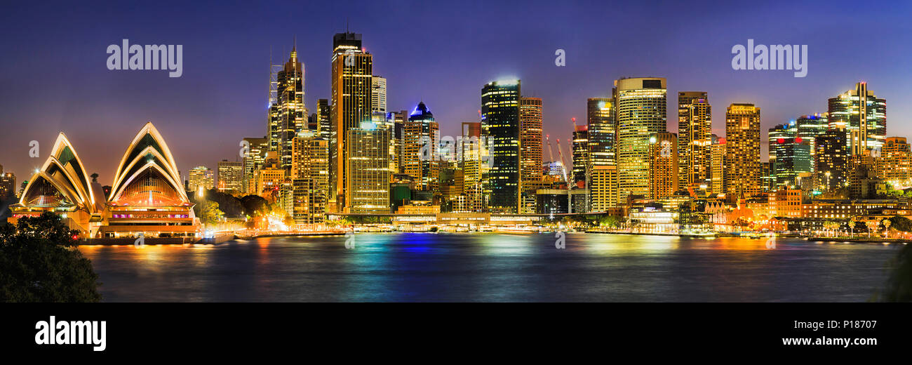 Sur le port de Sydney au bord de rives autour de Circular Quay quai entouré de repères CDB ville au coucher du soleil avec un éclairage lumineux reflétant dans Banque D'Images