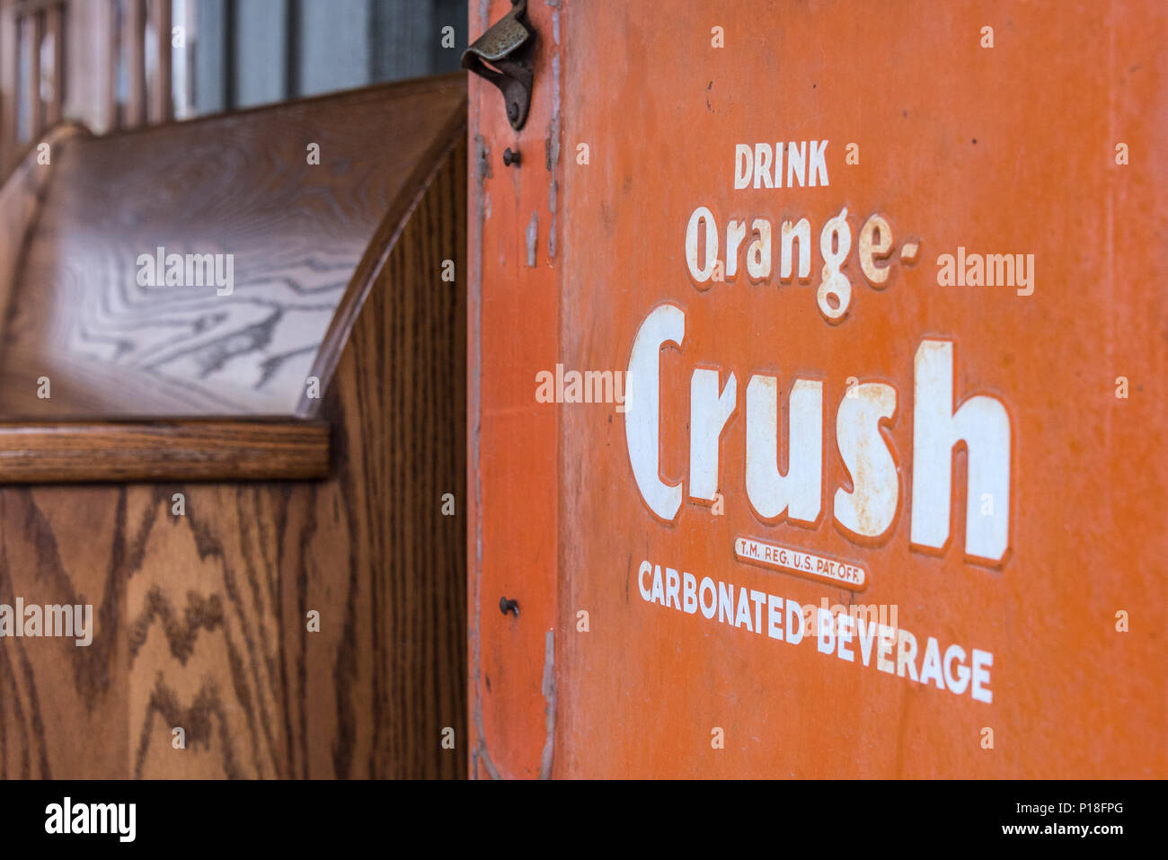 Vintage Orange Crush glacière avec ouvre-bouteille à côté d'une vieille église pew à Cracker Barrel Old Country Store à West Memphis, Arkansas. (USA) Banque D'Images