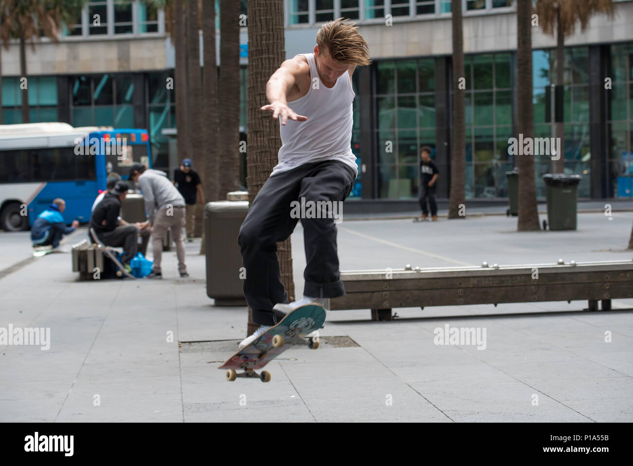 Un skate rider effectue un tour sur un banc dans la ville de Sydney, Australie Banque D'Images