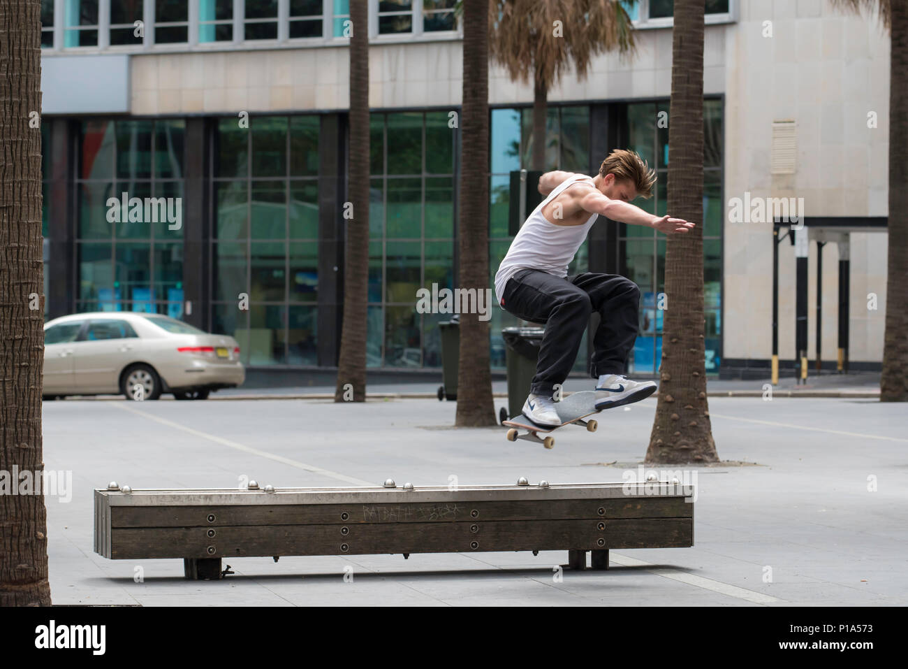 Un skate rider effectue un tour sur un banc dans la ville de Sydney, Australie Banque D'Images