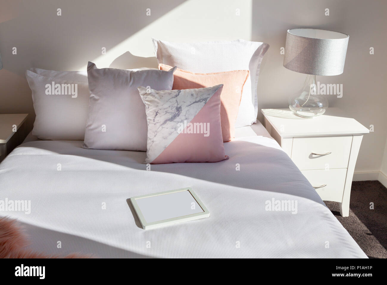 Arrangement élégant d'oreillers sur le lit et le cadre photo vide with copy space Banque D'Images