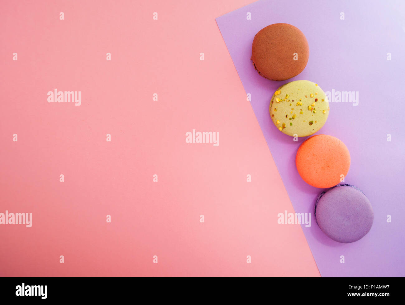 Quatre français délicieux dessert macarons sur fond multicolore avec texte de l'espace. Banque D'Images