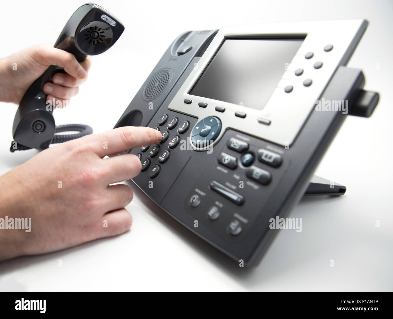 Faire un appel, l'homme est de composer sur le clavier du téléphone IP Banque D'Images