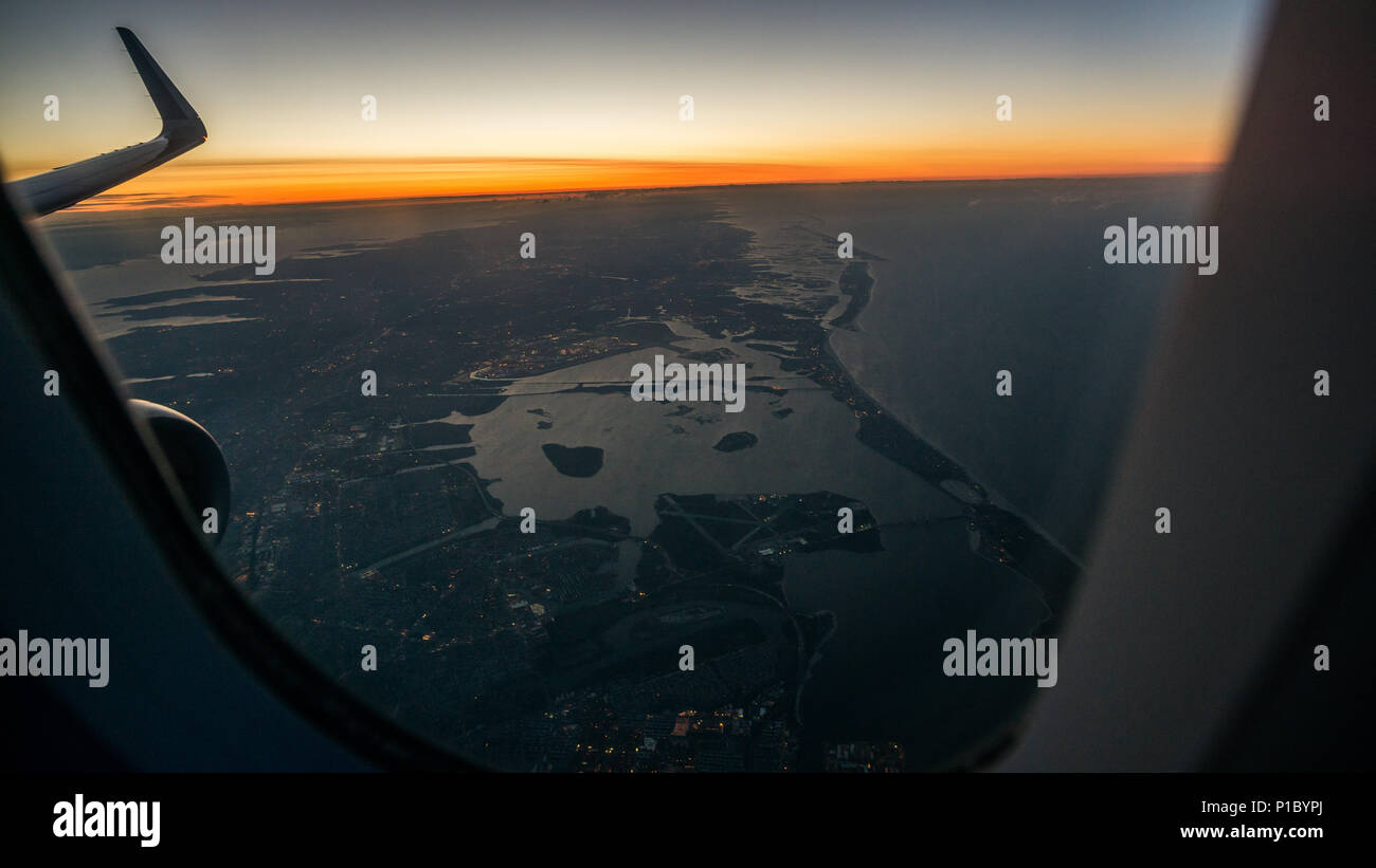 La vue à l'aube d'une fenêtre de l'avion peu avant son atterrissage à l'aéroport JFK de New York. Banque D'Images
