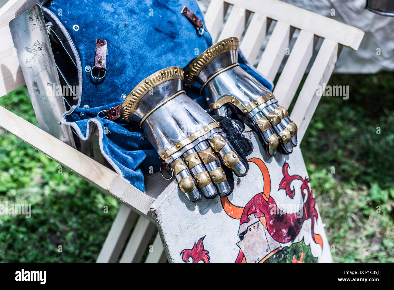 Chevalier médiéval metal gants à la main et bouclier sur chaise en bois. Armes traditionnelles au moyen age chevaliers festival à thème Banque D'Images
