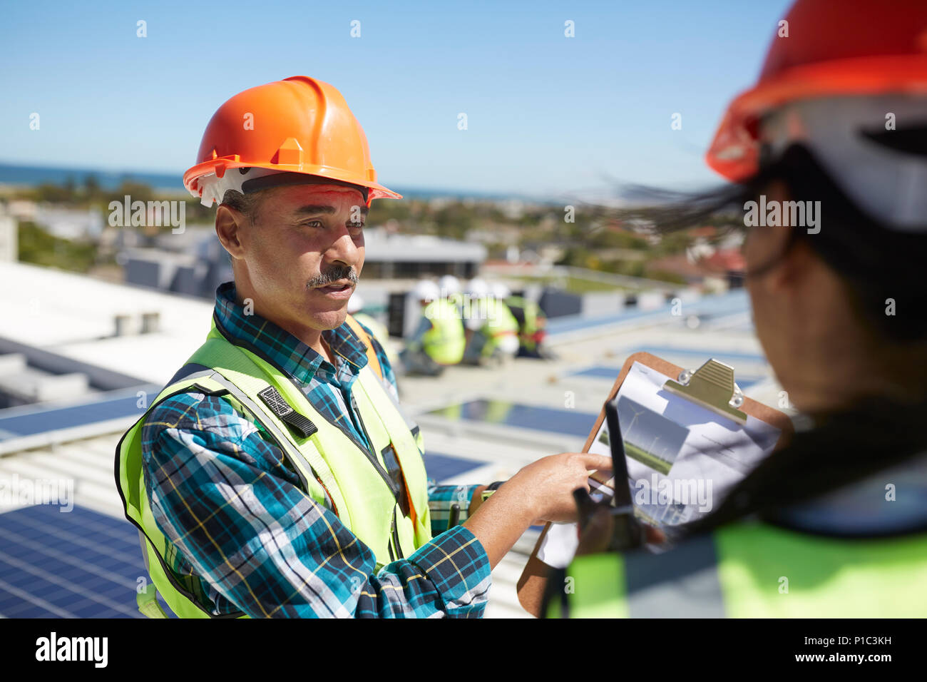 Engineers discussing paperwork at alternative energy power plant Banque D'Images Engineers discussing paperwork at alternative energy power plant Banque D'Images