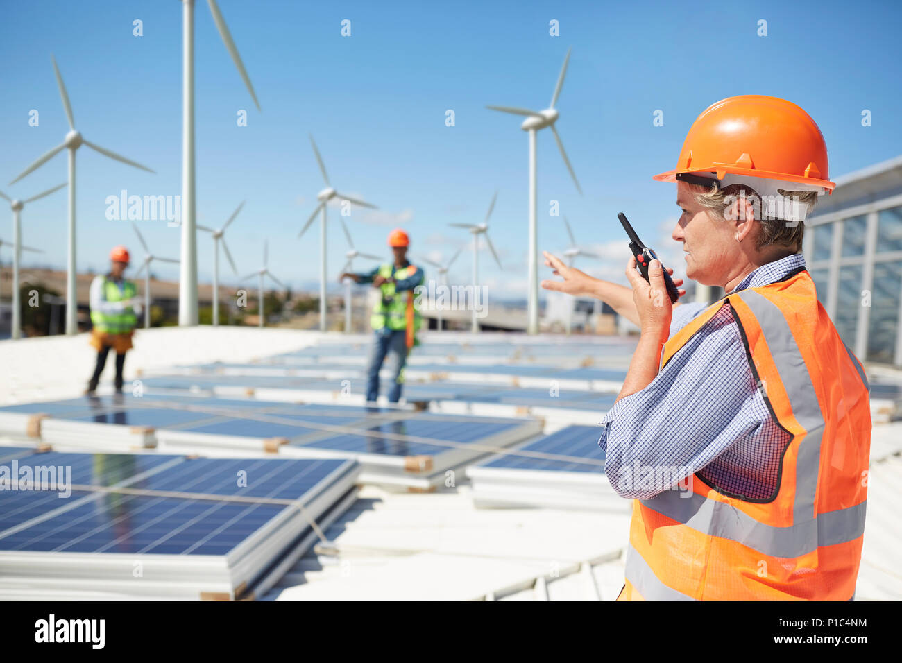 Ingénieur femelle à l'aide de talkie-walkie à alternative energy power plant Banque D'Images