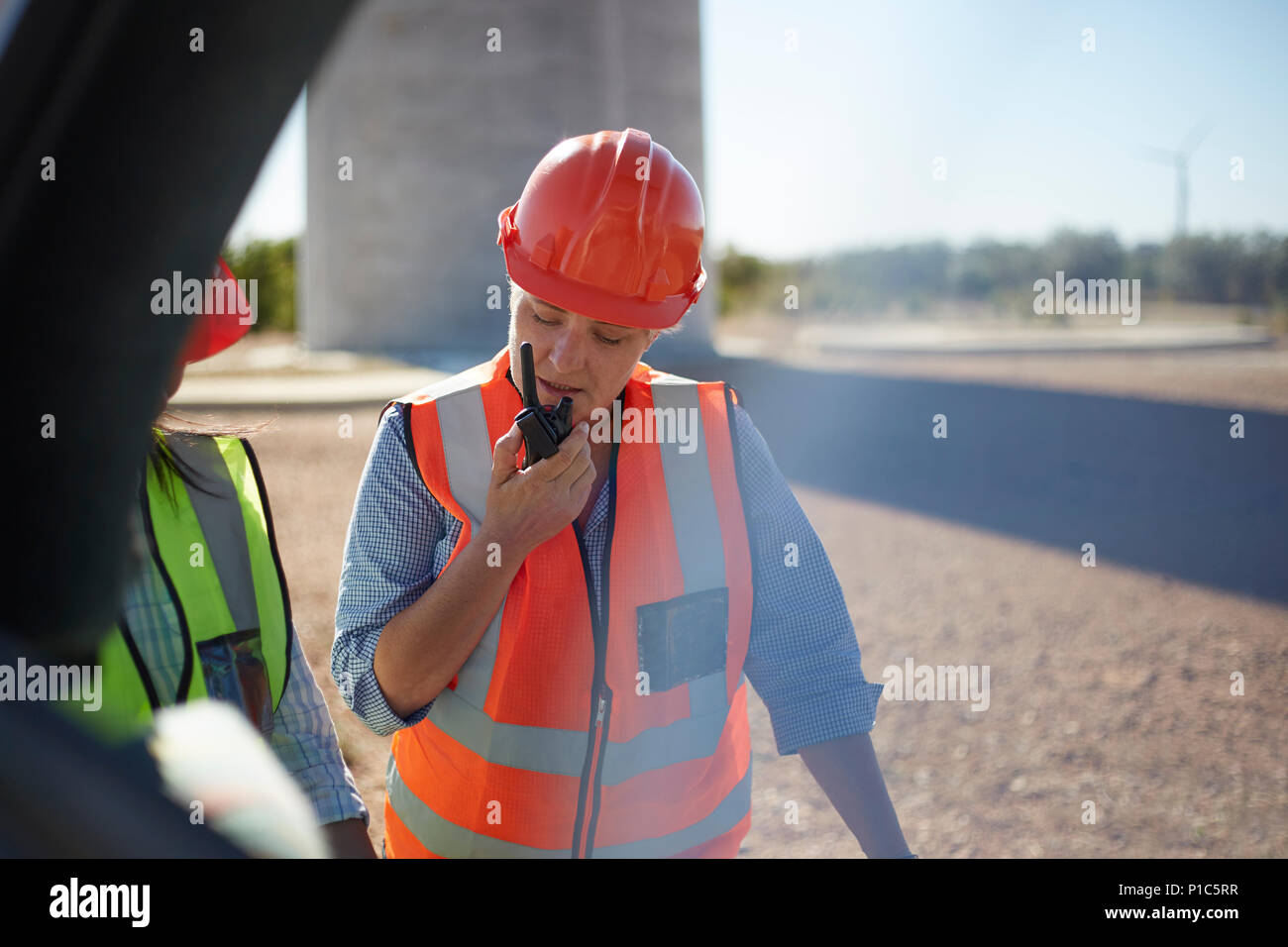 Travailleur féminin à l'aide de talkie-walkie au power plant Banque D'Images