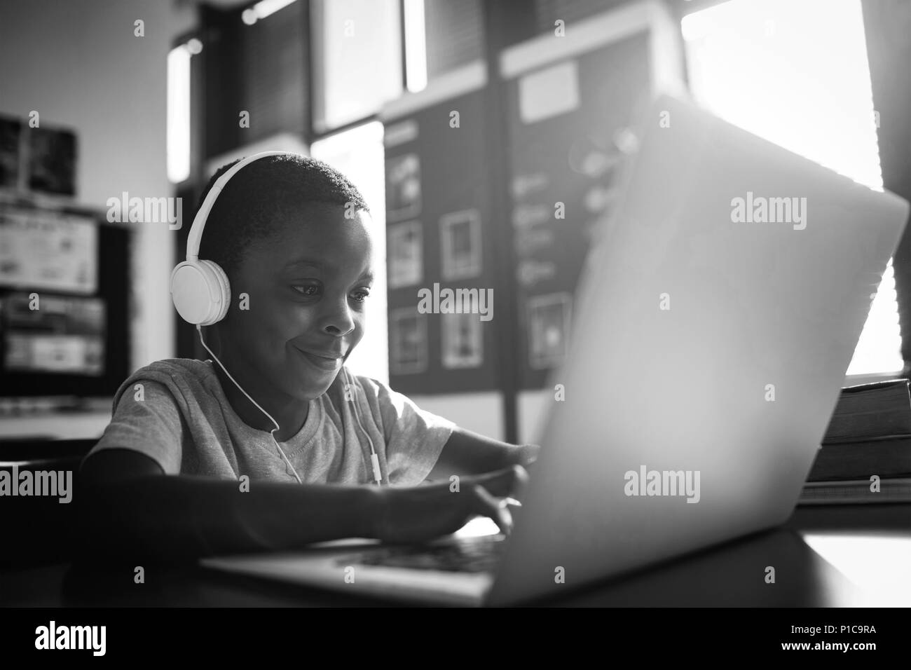 Boy listening music while using laptop Banque D'Images