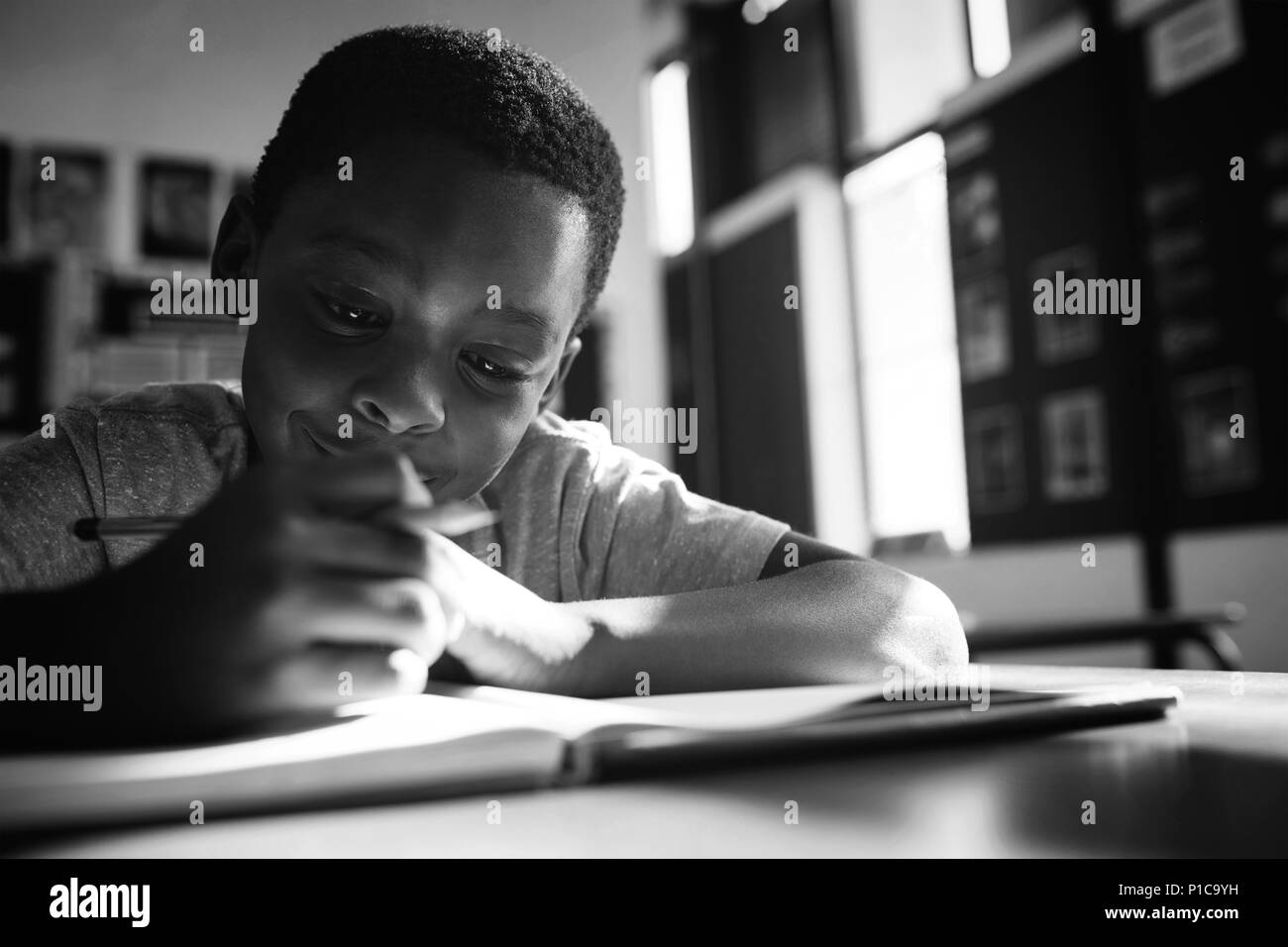 Boy writing in book Banque D'Images