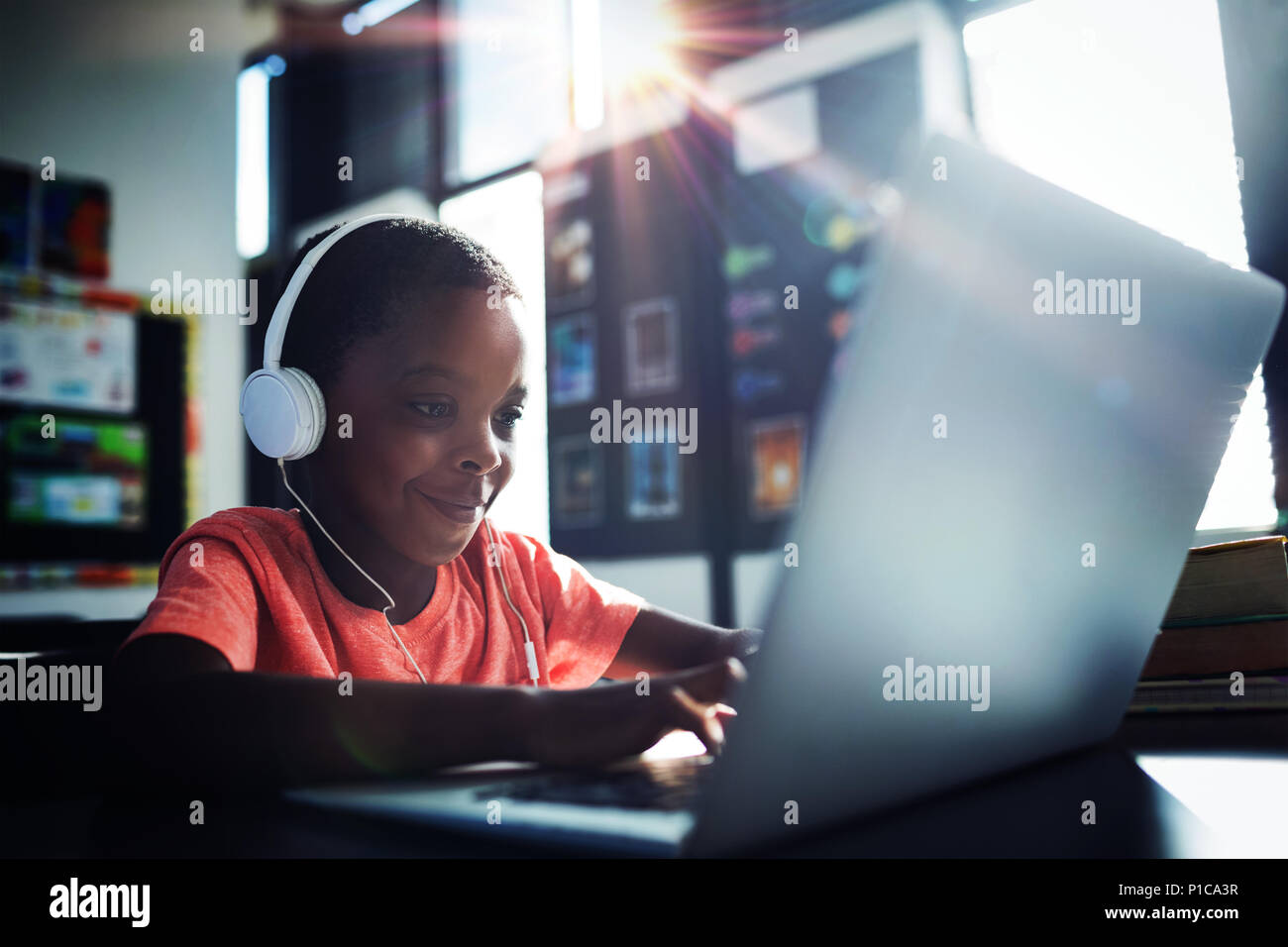 Boy listening music while using laptop Banque D'Images