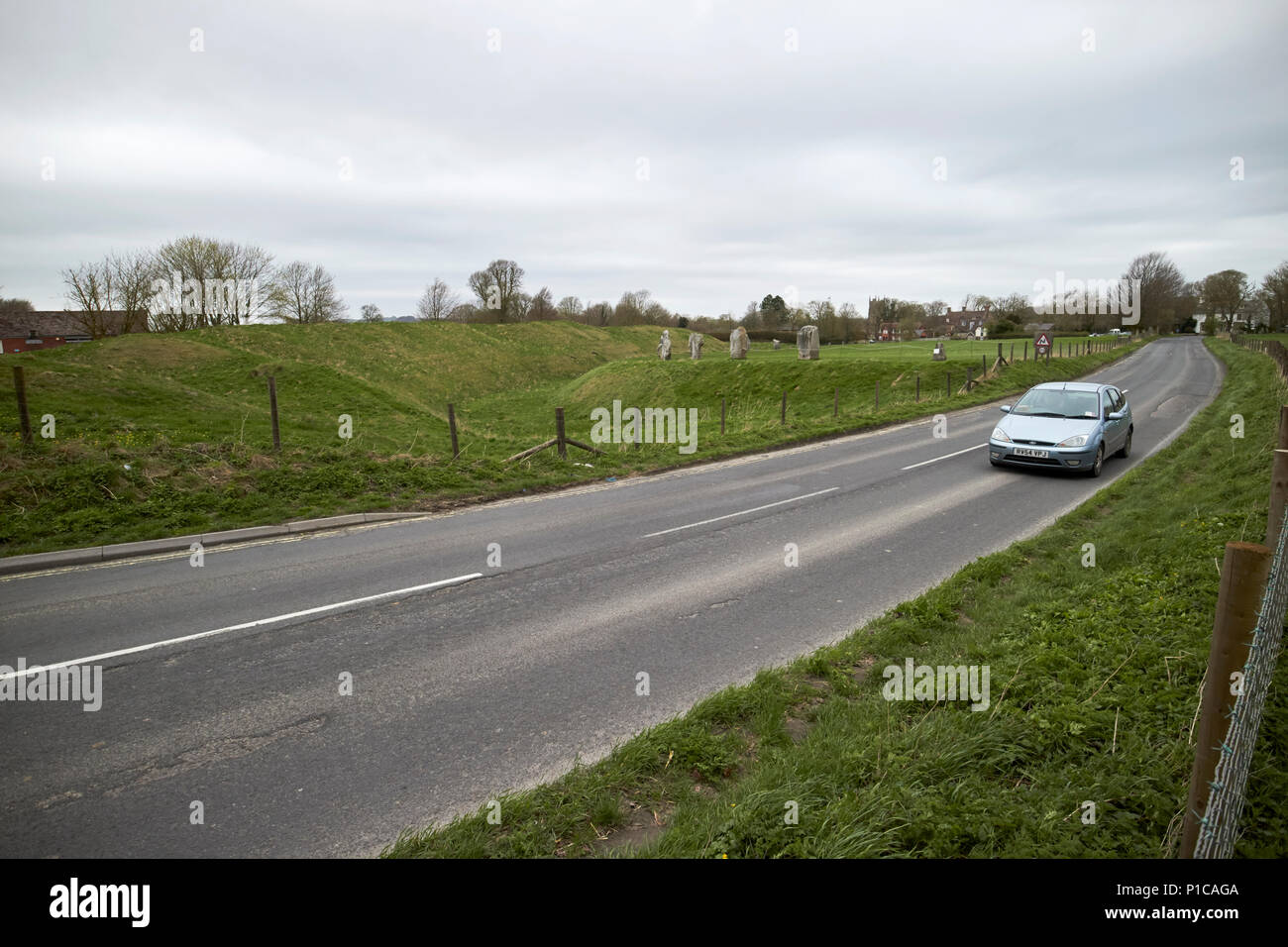 La conduite d'une voiture4361 Route à travers le henge fait de banque circulaire et tranchée autour d'Avebury Stone Circle avebury wiltshire england uk Banque D'Images