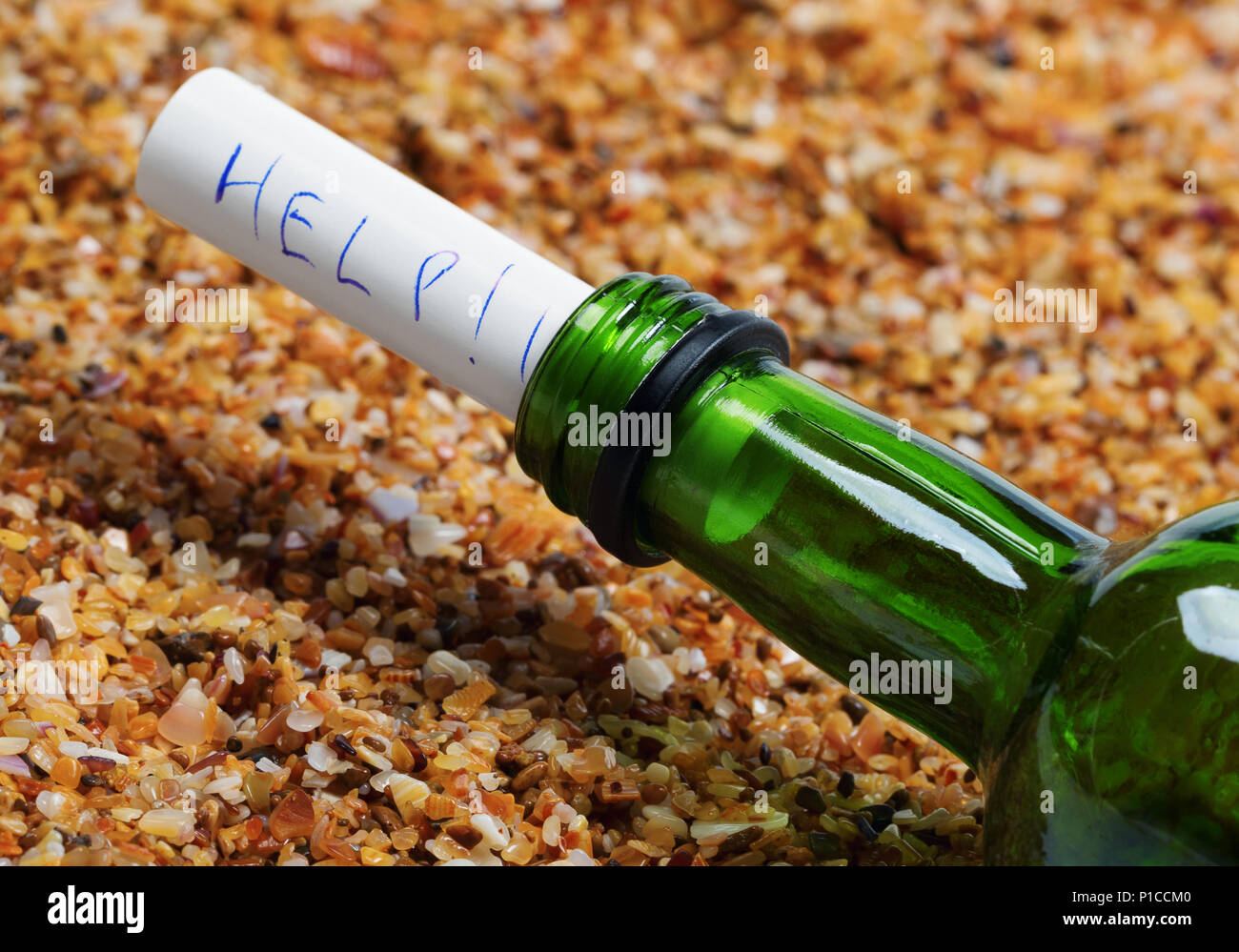 Bouteille de vin avec un message d'aide sur le sable sur la plage au soleil Journée d'été. Vue en gros plan. Banque D'Images