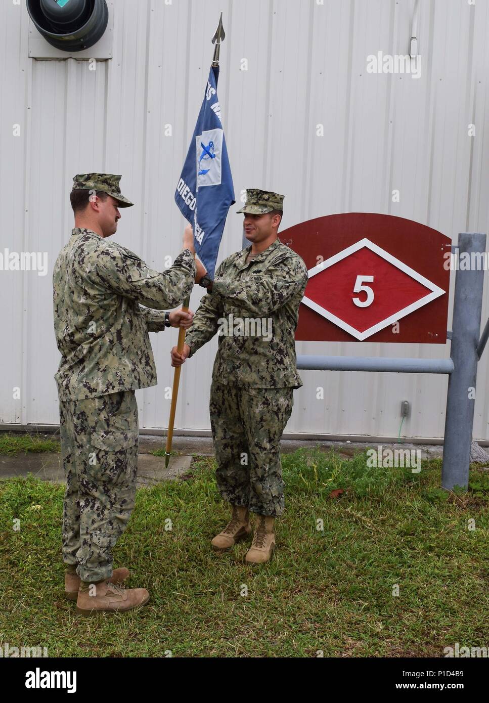 160928-N-ZI127-001 DIEGO GARCIA (oct. 6, 2016) un droit, Seabee, affectés à la construction navale (bataillon Mobile NMCB) 4, et Maître de 1re classe Javier Rivera, affecté à la retraite, 5 NMCB NMCB 4 couleurs au cours d'une cérémonie de chiffre d'affaires. NMCB 5 est le Pacifique occidental NMCB déployées à l'avant prêt à soutenir des opérations de combat majeures et l'aide humanitaire et les opérations de secours et de fournir l'ingénierie générale et le soutien civil à Marine, Marine Corps et des forces opérationnelles. Homeported au départ de Port Hueneme, Californie, 5 a 12 NMCB sites détachement déployé partout aux États-Unis un Banque D'Images