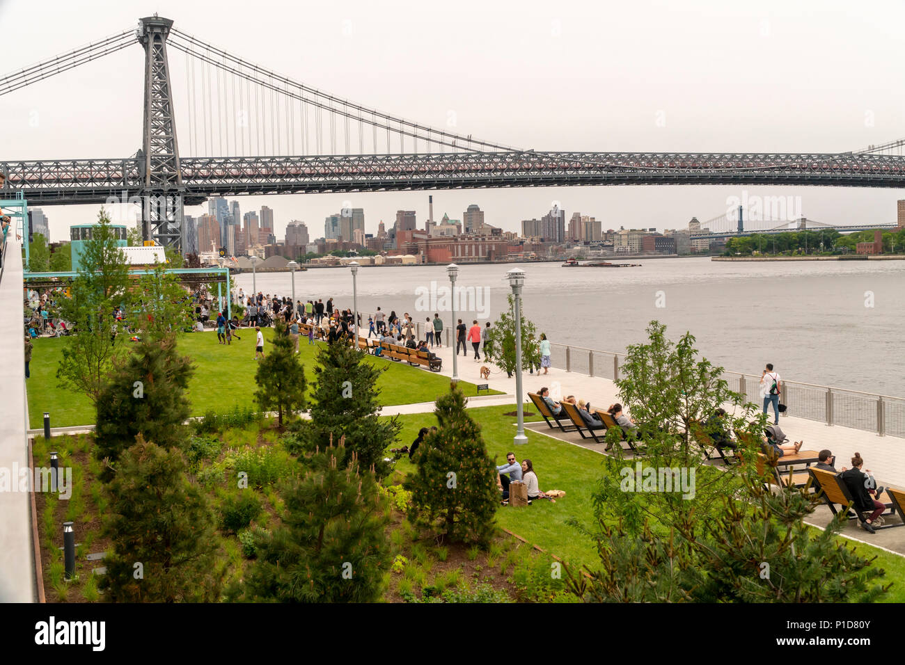 Malgré le mauvais temps des milliers de visiteurs se pressent à l'inauguration du parc de Domino dans le quartier de Williamsburg Brooklyn à New York le dimanche 10 Juin, 2018. L'occupation de l'emplacement de l'Domino Sugar Co., raffinerie fermée en 2004, les cinq acres d'espaces verts a d'eau, des toboggans, une passerelle surélevée, un stand de nourriture et Danny Meyer volley-ball ainsi que de nombreux autres équipements. Conçu par James Corner Field Operations, les architectes de la conception de la ligne haute, la brique de construction de la raffinerie, qui à un moment traitées 50 pour cent de tout le sucre dans le reste des États-Unis pour de Banque D'Images