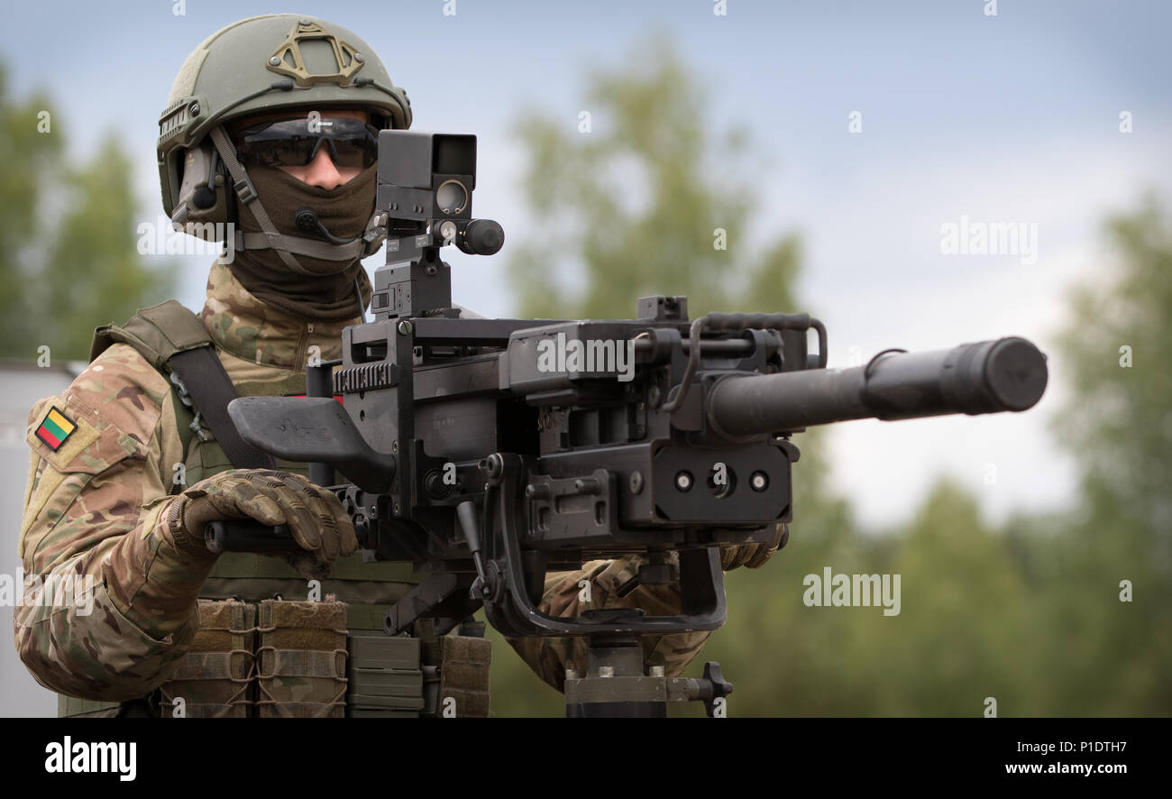 Un soldat, appartenant à l'OTAN une présence avancée battle group se place derrière son arme tout en participant à une exposition statique au cours de Sabre à Pabrade grève 18 Domaine de formation, la Lituanie, le 11 juin 2018. L'exposition statique se tient après éminents visiteurs éléments observés de la présence renforcée de l'avant groupes de combat effectuer un assaut de l'exercice. Grève 18 Sabre est un exercice multinational dont l'exécution est planifiée à partir de juin 3-15 que l'amélioration de l'avant les tests de présence (PEF) groupes de combat situé en Estonie, Lettonie, Lituanie et Pologne. L'exercice fait partie des objectifs de l'OTAN t Banque D'Images