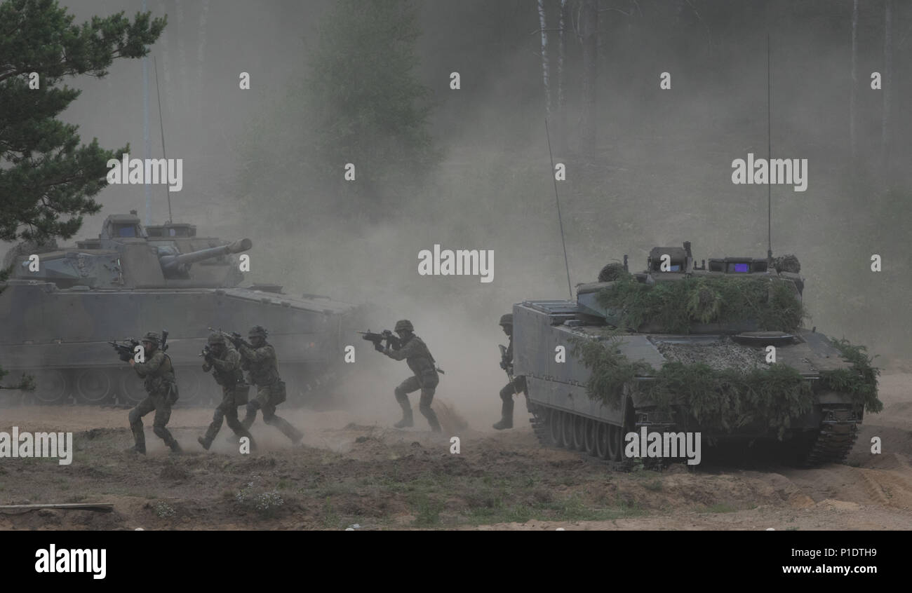 Des soldats appartenant à l'OTAN, une meilleure présence de l'avant groupes de combat Mener un exercice d'assaut et les bâtiments clairs pendant la grève à Pabrade 18 Sabre d'entraînement, la Lituanie, le 11 juin, 2018. L'assaut de l'exercice et plus tard l'affichage statique a été observé par d'éminents visiteurs provenant de plusieurs pays. Grève 18 Sabre est un exercice multinational dont l'exécution est planifiée à partir de juin 3-15 que l'amélioration de l'avant les tests de présence (PEF) groupes de combat situé en Estonie, Lettonie, Lituanie et Pologne. L'exercice fait partie des objectifs de l'OTAN afin de démontrer l'interopérabilité de l'Alliance et d'aider chaque rési Banque D'Images