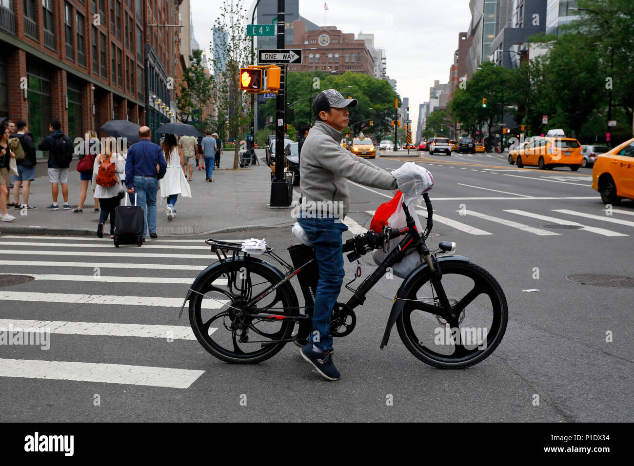 Une prestation alimentaire NYC personne sur un vélo électrique Banque D'Images