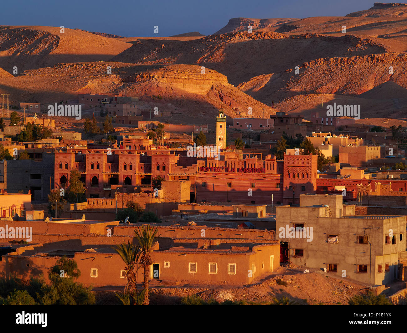 Ville berbère traditionnel au coucher du soleil : le rose les rayons du soleil illuminent les bâtiments en argile au rythme de ton, comme les montagnes environnantes, le Maroc. Banque D'Images