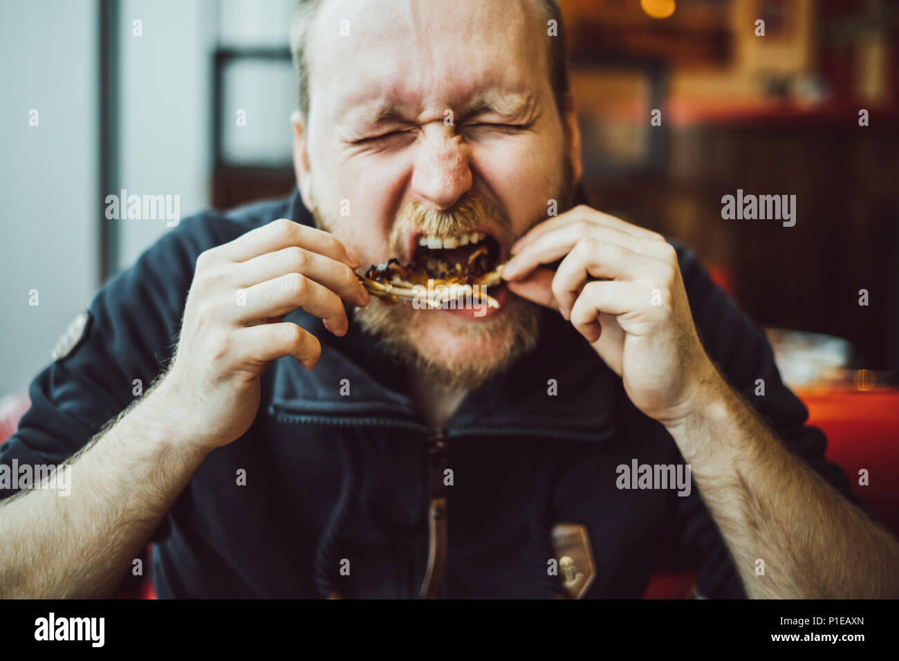 L'homme est de manger fast food in a restaurant, Brighton, Angleterre Banque D'Images