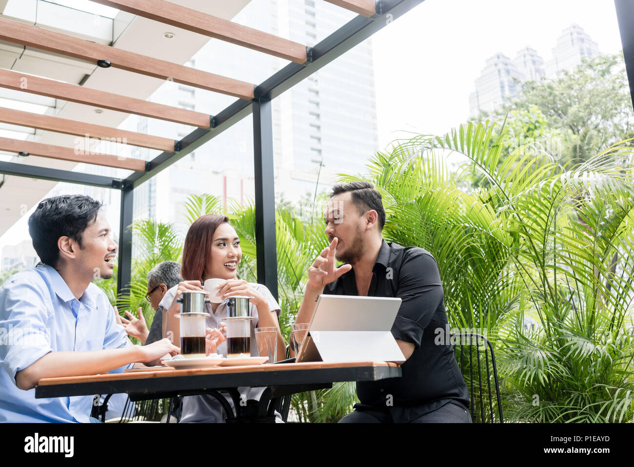 Café vietnamien servi sur la table des trois amis à l'extérieur Banque D'Images