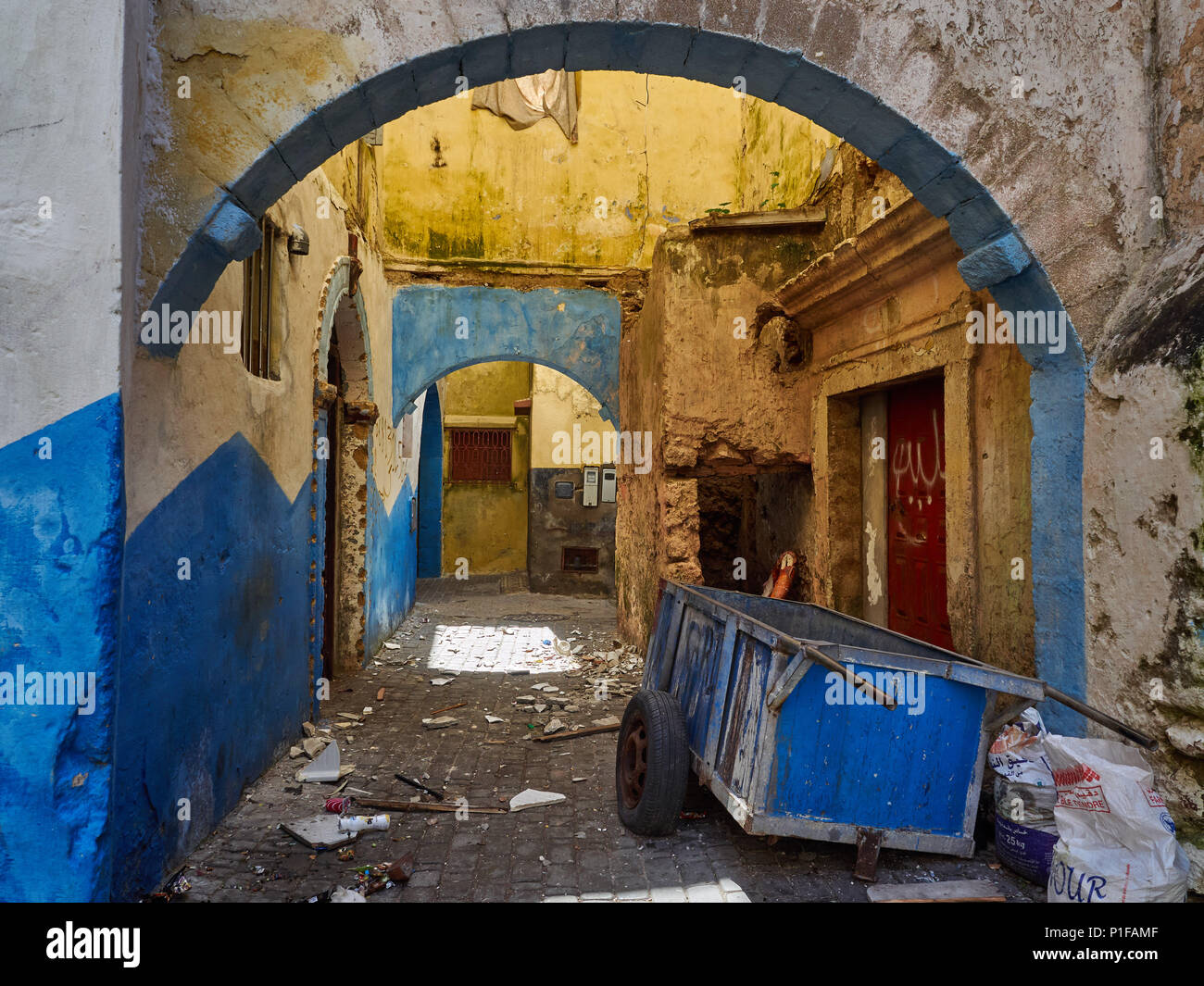 Grunge fond urbain avec des murs bleus et jaunes et des arches de maisons du portugais medina El Jadida, Maroc. Banque D'Images