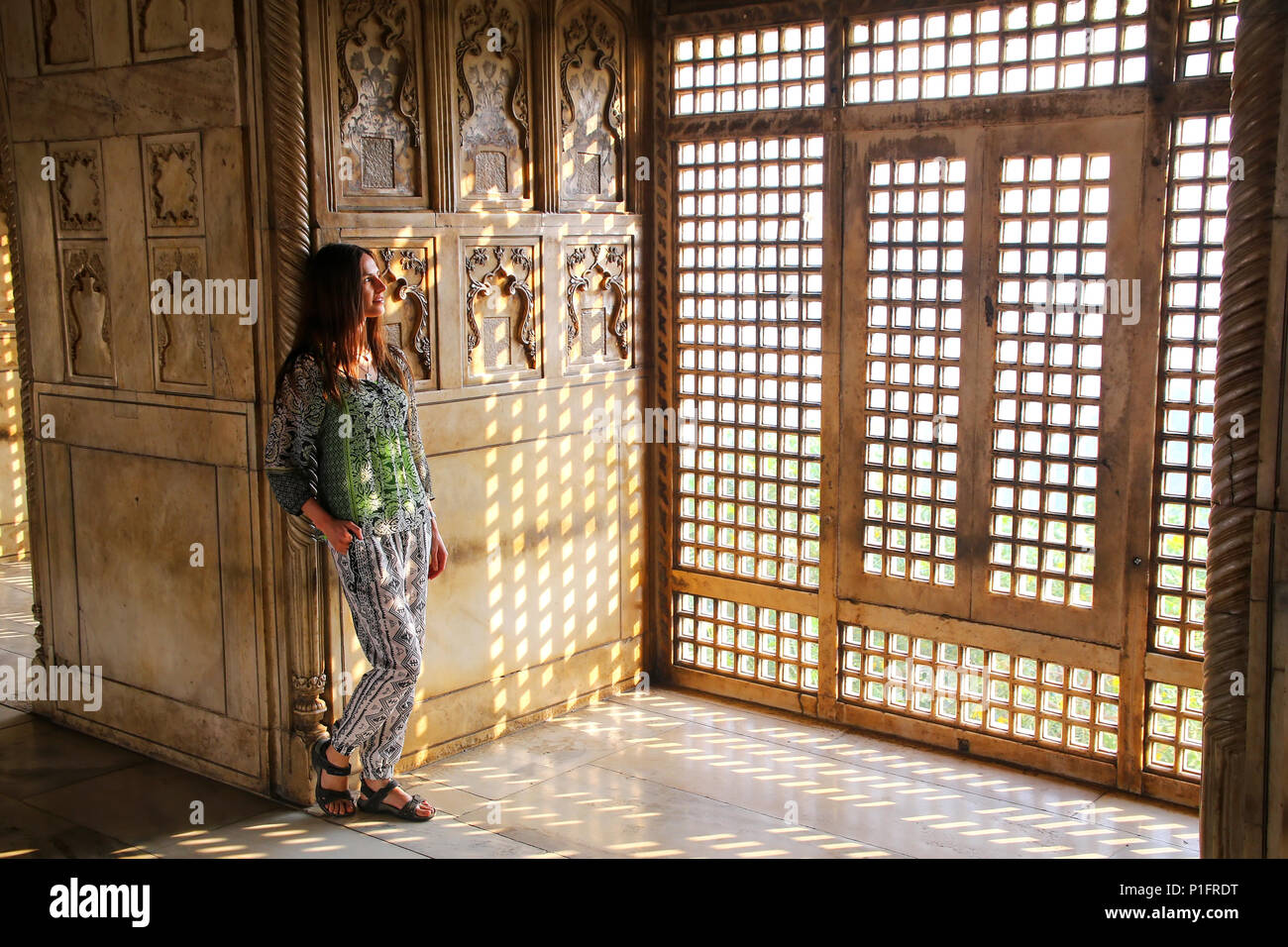 Jeune femme debout près de la fenêtre dans Khas Mahal, Fort d'Agra, Uttar Pradesh, Inde. Le fort a été construit principalement comme une structure militaire, mais a été plus tard Banque D'Images