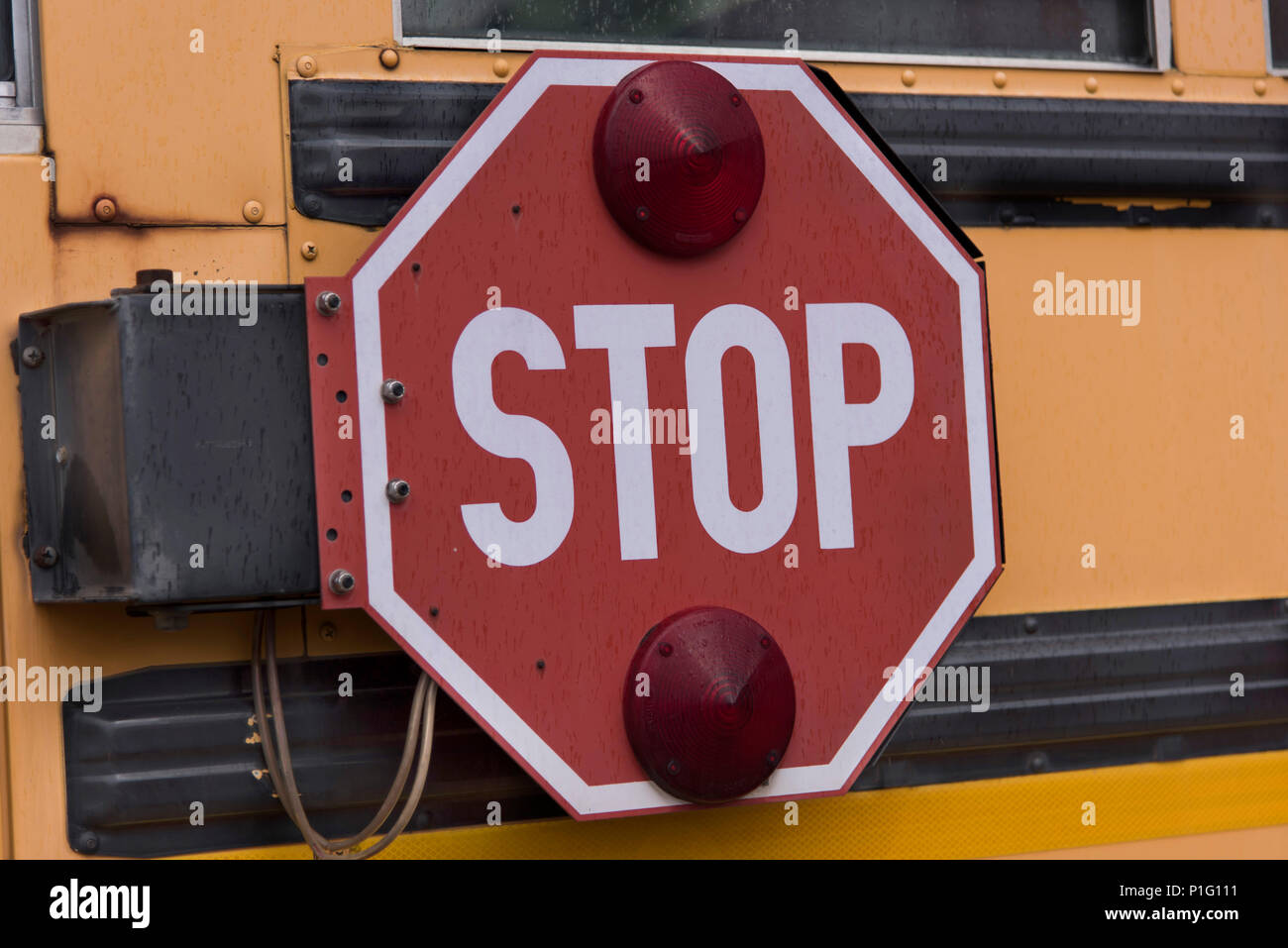 Bossier City, Louisiane, États-Unis - 16 janvier 2017 : un bras plié panneau stop sur un autobus scolaire stationné dans la cour de l'école. Banque D'Images