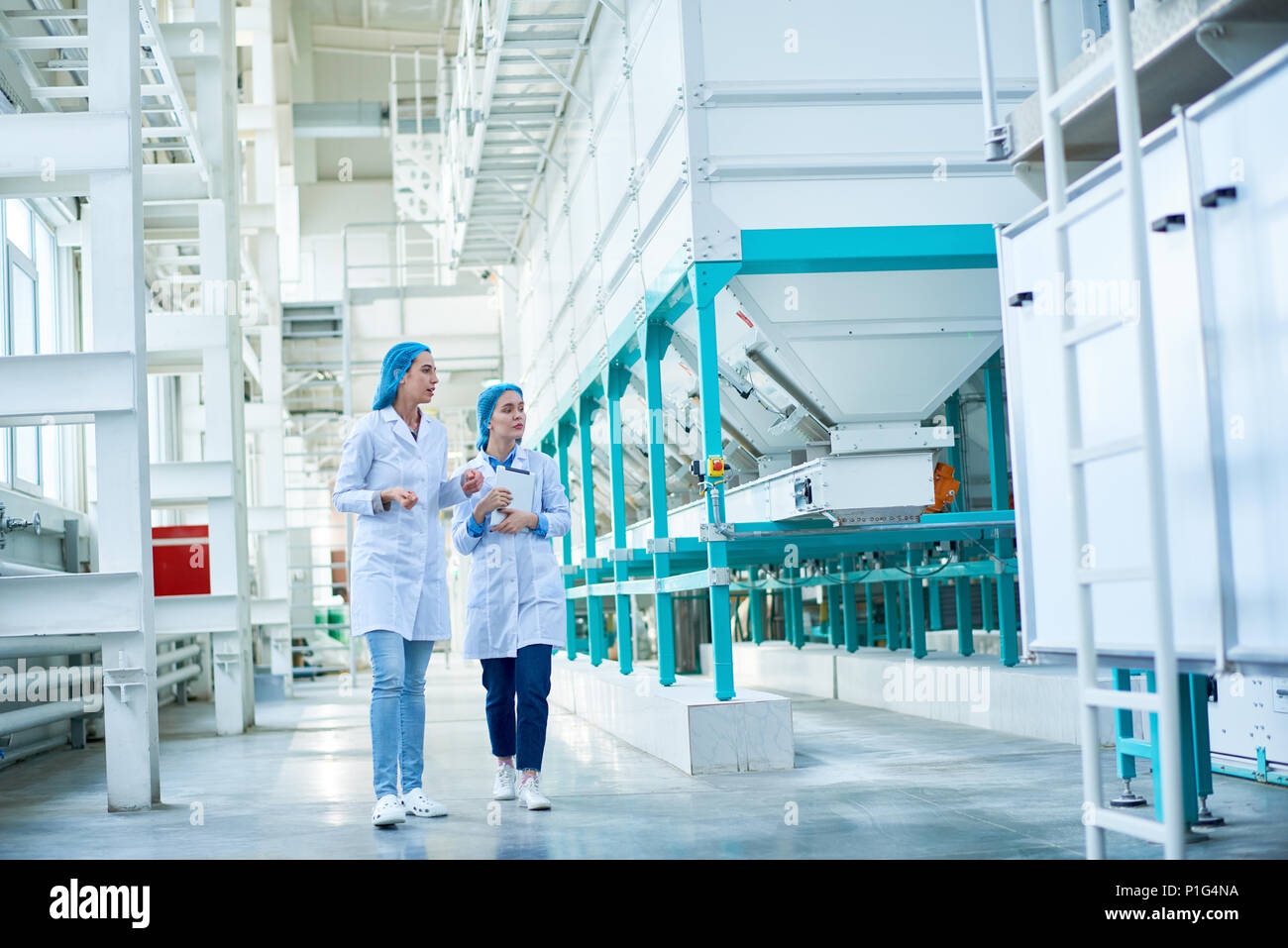 Les jeunes femmes marchant à l'usine Banque D'Images Les jeunes femmes marchant à l'usine Banque D'Images