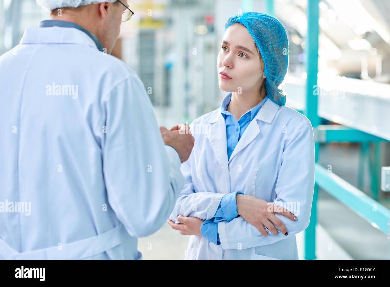 Jeune femme à l'écoute de superviseur de l'usine Banque D'Images