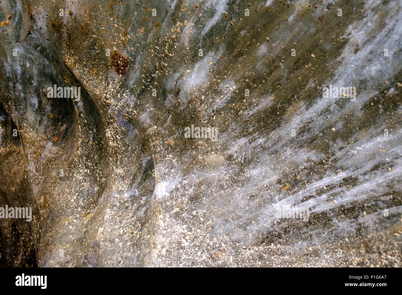 Le mur d'une grotte de glace derrière 'Laguna de los Témpanos', près d'Ushuaia, présente de superbes textures dorées et des lignes blanches. Banque D'Images