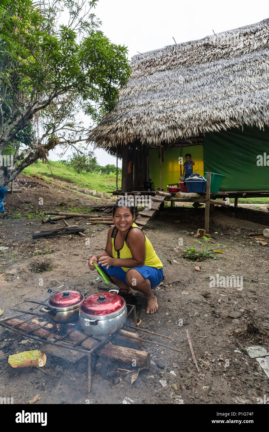 Femme préparant un repas sur feu ouvert, village de San Francisco, Loreto, Pérou Banque D'Images