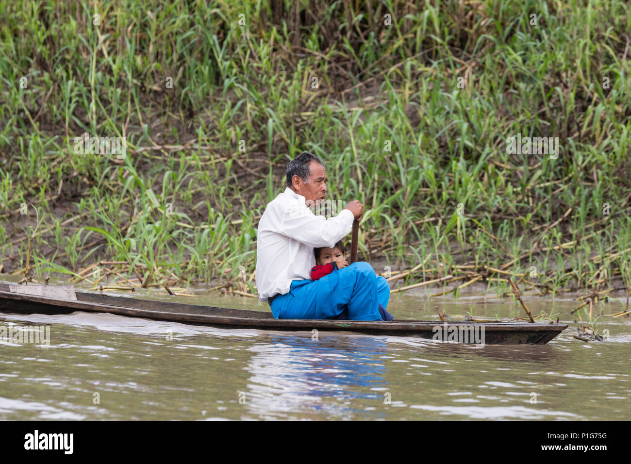 Man paddling pirogue, Puerto Miguel, le haut bassin du fleuve Amazone, Loreto, Pérou Banque D'Images