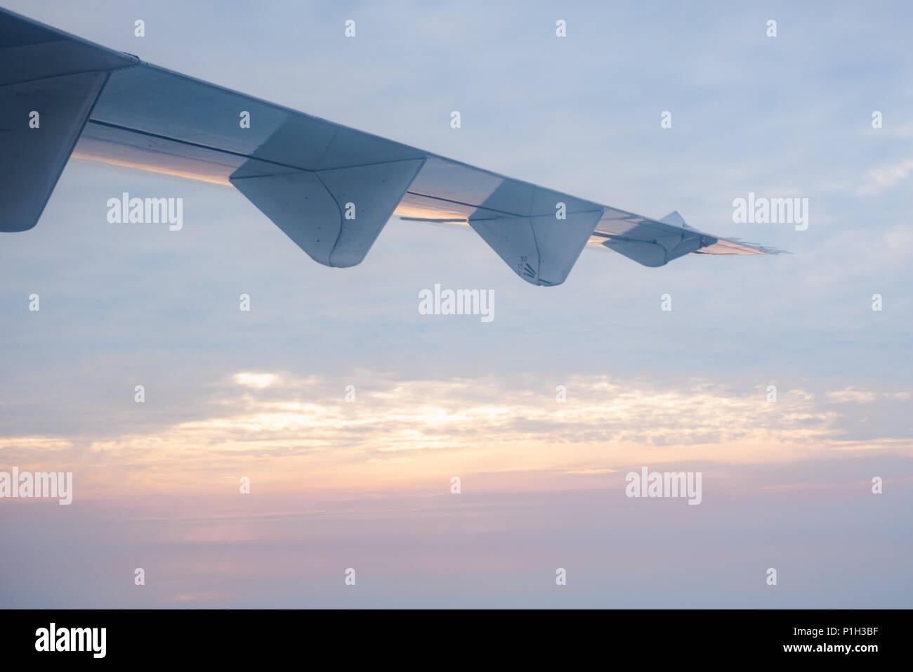 Des ailes d'avion en vol dans le ciel à l'heure du lever, transport et travel concept Banque D'Images