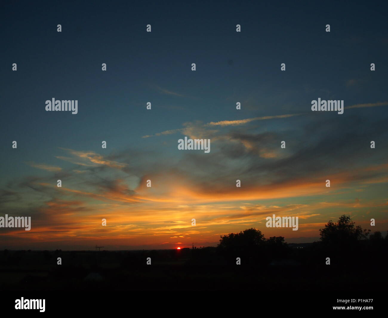 Le coucher du soleil, Bedfordshire, Royaume-Uni, près de Milton Keynes, ciel bleu et orange Banque D'Images