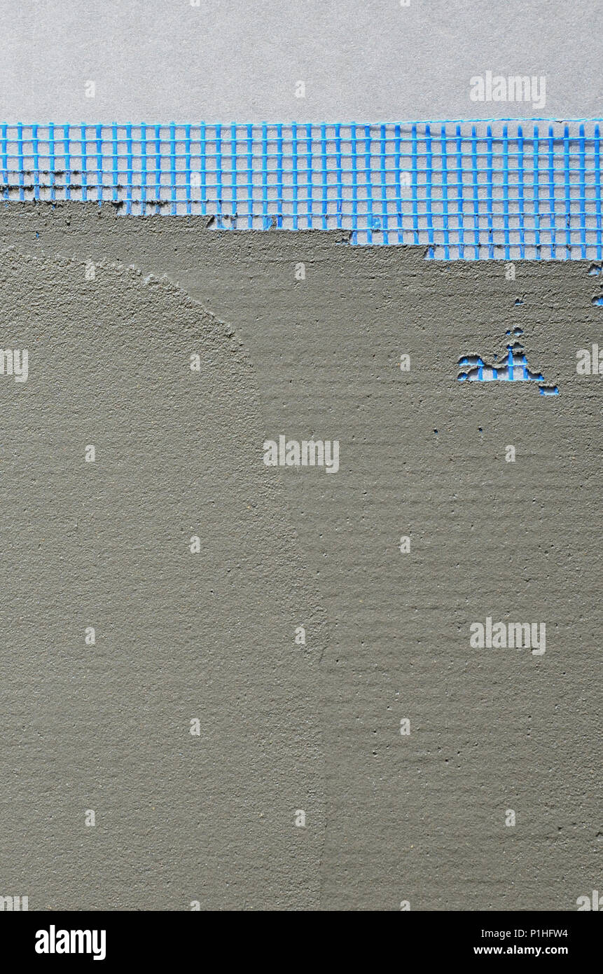 La texture du mur, recouvert de plaques de polystyrène mousse gris, recouvert d'un treillis d'armature bleu et recouvert d'un mélange de collage. Sta Banque D'Images